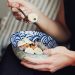 person holding spoon and bowl of food